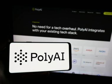 Stuttgart, Almanya - 03-10-2024: İnternet sitesi önünde konuşma amaçlı yapay zeka şirketi PolyAI Ltd. 'nin logosuna sahip kişi. Telefon ekranına odaklan.