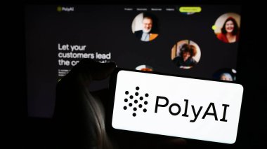 Stuttgart, Almanya - 03-10-2024: İnternet sayfasının önünde konuşma amaçlı yapay zeka şirketi PolyAI Ltd. 'nin logosuna sahip cep telefonu sahibi kişi. Telefon ekranına odaklan.