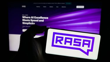 Stuttgart, Almanya - 03-12-2024: Web sayfası önünde Amerikan sohbet şirketi Rasa Technologies Inc. 'nin logosuna sahip cep telefonu sahibi kişi. Telefon ekranına odaklan.