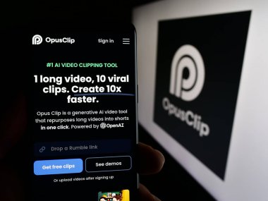 Stuttgart, Almanya - 03-13-2024: Yapay zeka video düzenleme şirketi Opus Clip 'in logolu web sayfasını elinde tutan kişi. Telefon ekranının merkezine odaklan.