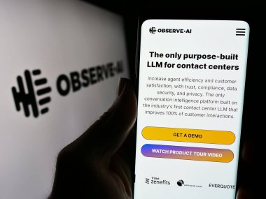 Stuttgart, Almanya - 03-13-2024: Yapay zeka merkezi Observe.I. logolu web sitesi ile akıllı telefon tutan kişi. Telefon ekranının merkezine odaklan.