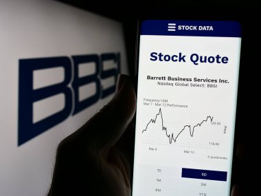 Stuttgart, Almanya - 03-13-2024: Logolu danışmanlık şirketi Barrett Business Services Inc. (BBSI) 'in internet sayfası ile cep telefonu tutan kişi. Telefon ekranının merkezine odaklan.