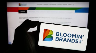 Stuttgart, Almanya - 03-13-2024: İnternet sitesi önünde Bloomin 'Brands Inc.' in logosuna sahip kişi. Telefon ekranına odaklan.