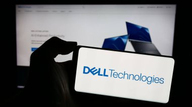 Stuttgart, Almanya - 03-13-2024: Amerikan teknoloji şirketi Dell Technologies Inc. 'nin logosu olan cep telefonu sahibi kişi iş sayfasının önünde. Telefon ekranına odaklan.