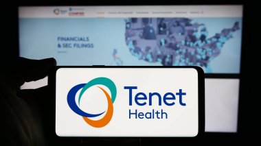 Stuttgart, Almanya - 03-13-2024: İnternet sayfası önünde Amerikan sağlık hizmetleri şirketi Tenet Healthcare Corporation 'ın logosuyla cep telefonu tutan kişi. Telefon ekranına odaklan.