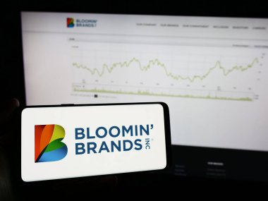 Stuttgart, Almanya - 03-13-2024: İnternet sayfasının önünde Bloomin 'Brands Inc.' in logosu olan cep telefonu sahibi kişi. Telefon ekranına odaklan.