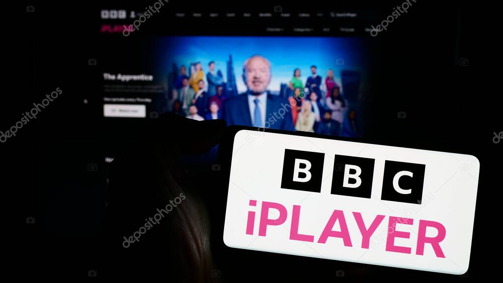 Stuttgart, Germany - 03-07-2024: Person holding mobile phone with logo of British video on demand service BBC iPlayer in front of company web page. Focus on phone display.