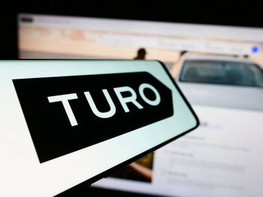 Stuttgart, Almanya - 03-18-2024: İş dünyasının web sitesi önünde, akranlar arası araba paylaşım şirketi Turo Inc. 'nin logosuna sahip akıllı telefon. Telefon ekranının merkez soluna odaklan.