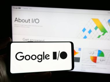 Stuttgart, Almanya - 03-19-2024: İnternet sitesi önünde yıllık geliştirme konferansı logosu olan akıllı telefon sahibi kişi. Telefon ekranına odaklan.