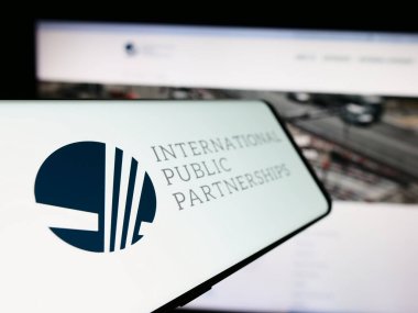 Stuttgart, Almanya - 03-20-2024: İngiliz şirketi International Public Partnerships Limited 'in logosunun yer aldığı cep telefonu iş web sitesi önünde. Telefon ekranının soluna odaklan.