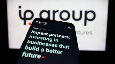 Stuttgart, Almanya - 03-23-2024: İngiliz fikri mülkiyet şirketi IP Group plc 'nin web sayfası ve iş logosu önünde cep telefonu. Telefon ekranının sol üst kısmına odaklan.