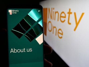 Stuttgart, Almanya - 03-25-2024: Varlık yönetimi şirketi doksan bir Limited 'in web sayfası ile akıllı telefon sahibi kişi logonun önünde. Telefon ekranının merkezine odaklan.