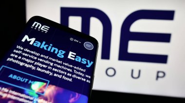 Stuttgart, Almanya - 03-25-2024: İngiliz otomat firması ME Group International plc 'in web sitesiyle birlikte logo önünde cep telefonu. Telefon ekranının sol üst kısmına odaklan.