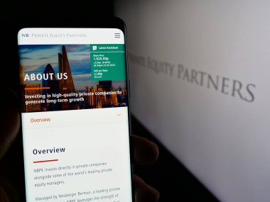 Stuttgart, Almanya - 03-25-2024: İngiliz şirketi NB Private Equity Partners Ltd. (NBPE) 'nin logolu web sayfası ile cep telefonu tutan kişi. Telefon ekranının merkezine odaklan.