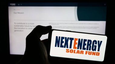 Stuttgart, Almanya - 03-25-2024: İçinde yatırım şirketi NextEnergy Solar Fund Limited 'in logosu bulunan akıllı telefon sahibi kişi web sitesi önünde. Telefon ekranına odaklan.