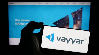 Stuttgart, Almanya - 03-27-2024: İsrailli yarı iletken şirket Vayyar Imaging Ltd. 'nin logosu olan cep telefonu sahibi kişi iş sayfasının önünde. Telefon ekranına odaklan.