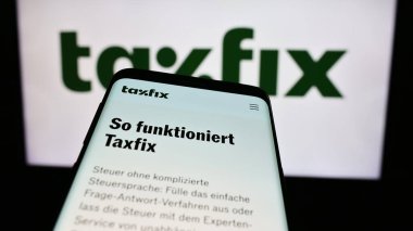 Stuttgart, Almanya - 03-28-2024: Alman vergi yazılım şirketi Taxfix SE 'nin web sitesi ile birlikte iş logosu önünde cep telefonu. Telefon ekranının sol üst kısmına odaklan.