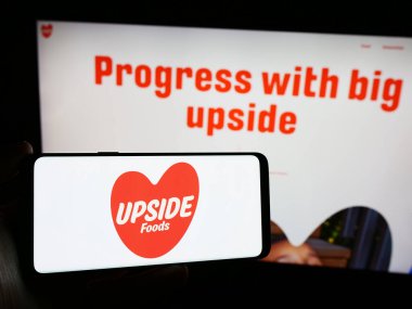 Stuttgart, Almanya - 03-28-2024: Üzerinde Amerikan kültür şirketi Upside Foods Inc. 'nin logosu bulunan cep telefonu sahibi kişi iş sayfasının önünde. Telefon ekranına odaklan.