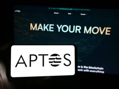 Stuttgart, Almanya - 03-28-2024: Protokol geliştirme kuruluşu Aptos Foundation 'ın logosuna sahip akıllı telefon sahibi kişi web sitesi önünde. Telefon ekranına odaklan.