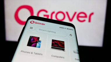 Stuttgart, Almanya - 03-28-2024: Alman tüketici elektroniği kiralama şirketi Grover 'ın web sitesi ile birlikte iş logosu önünde cep telefonu. Telefon ekranının sol üst kısmına odaklan.