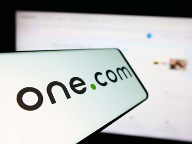 Stuttgart, Almanya - 04-02-2024: İnternet sunuculuğu şirketi One.com Group 'un logosunun yer aldığı cep telefonu. Telefon ekranının soluna odaklan.