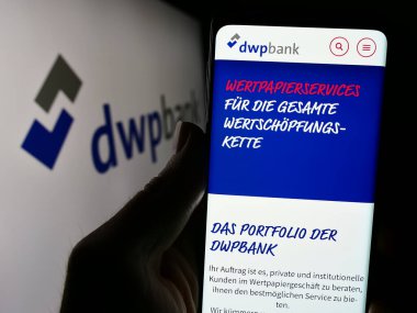 Stuttgart, Almanya - 04-02-2024: Logo önünde Deutsche WertPapierService Bank AG (dwpbank) şirketinin web sitesi ile akıllı telefon sahibi olan kişi. Telefon ekranının merkezine odaklan.