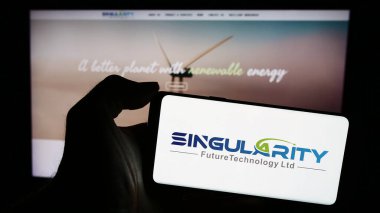 Stuttgart, Almanya - 04-02-2024: Tekillik Gelecek Teknoloji Ltd. şirketinin logosuna sahip cep telefonu sahibi kişi iş sayfasının önünde. Telefon ekranına odaklan.