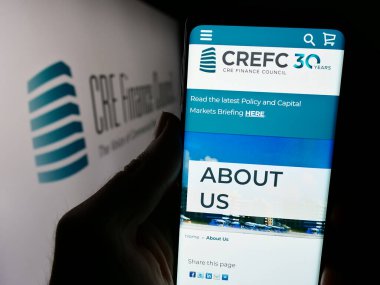 Stuttgart, Almanya - 04-04-2024: Logo önünde Ticaret Derneği CRE Finans Konseyi (BREFC) web sitesi bulunan cep telefonu sahibi kişi. Telefon ekranının merkezine odaklan.