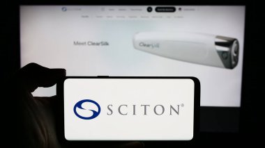 Stuttgart, Almanya - 04-05-2024: İş sayfası önünde ABD 'li tıbbi cihaz şirketi Sciton Inc.' in logosuyla cep telefonu tutan kişi. Telefon ekranına odaklan.