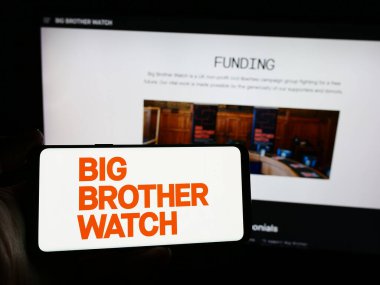 Stuttgart, Almanya - 04-05-2024: İnternet sitesi önünde Big Brother Watch adlı İngiliz kampanya örgütünün logosuna sahip kişi. Telefon ekranına odaklan.