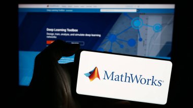 Stuttgart, Almanya - 04-05-2024: İnternet sayfasının önünde Amerikan bilgisayar yazılım şirketi The MathWorks Inc. 'in logosu olan cep telefonu sahibi kişi. Telefon ekranına odaklan.