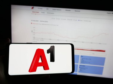 Stuttgart, Almanya - 04-07-2024: İnternet sitesi önünde telekomünikasyon şirketi Telekom Austria AG 'nin (A1) logosuna sahip akıllı telefon sahibi kişi. Telefon ekranına odaklan.