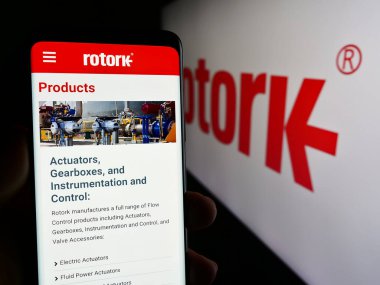 Stuttgart, Almanya - 04-07-2024: İngiliz akış kontrol ekipmanları şirketi Rotork plc 'nin web sayfası ile logo önünde akıllı telefon tutan kişi. Telefon ekranının merkezine odaklan.