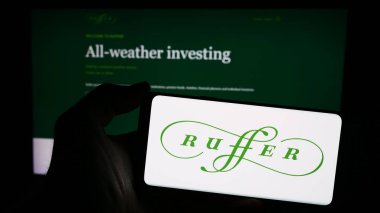 Stuttgart, Almanya - 04-07-2024: İngiliz Ruffer Yatırım Şirketi logosuna sahip akıllı telefon sahibi kişi web sitesinin önünde. Telefon ekranına odaklan.