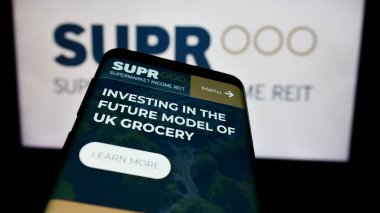Stuttgart, Almanya - 04-08-2024: İngiliz emlak şirketi Supermarket Income REIT plc 'nin web sitesine sahip akıllı telefon iş logosu önünde. Telefon ekranının sol üst kısmına odaklan.