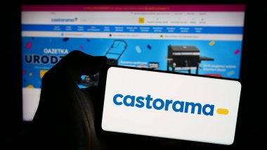 Stuttgart, Almanya - 04-08-2024: Ev geliştirme mağazası zincir şirketi Castorama 'nın logosunun yer aldığı cep telefonu sahibi kişi iş sayfası önünde. Telefon ekranına odaklan.