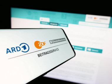 Stuttgart, Germany - 04-10-2024: Mobile phone with logo of ARD ZDF Deutschlandradio Beitragsservice in front of website. Focus on center of phone display. clipart