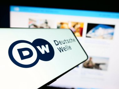 Stuttgart, Almanya - 04-10-2024: İnternet sitesi önünde Alman devlet yayın kuruluşu Deutsche Welle 'in (DW) logosuna sahip cep telefonu. Telefon ekranının soluna odaklan.
