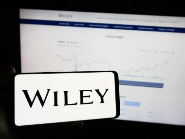 Stuttgart, Almanya - 04-12-2024: Amerikan yayıncılık şirketi John Wiley and Sons Inc. 'in logosunun bulunduğu cep telefonu web sayfasının önünde duruyor. Telefon ekranına odaklan.