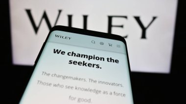 Stuttgart, Almanya - 04-12-2024: ABD 'li yayıncılık şirketi John Wiley and Sons Inc.' in web sitesi ile şirket logosu önünde akıllı telefon. Telefon ekranının sol üst kısmına odaklan.