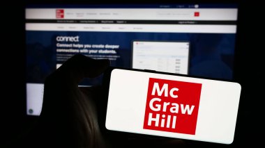 Stuttgart, Almanya - 04-12-2024: Amerikan yayıncılık şirketi McGraw Hill LLLC 'nin logosuna sahip cep telefonu sahibi kişi iş sayfasının önünde. Telefon ekranına odaklan.