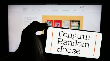 Stuttgart, Almanya - 04-12-2024: Amerikan yayıncılık şirketi Penguen Random House 'un logosuyla cep telefonu sahibi kişi iş sayfasının önünde. Telefon ekranına odaklan.