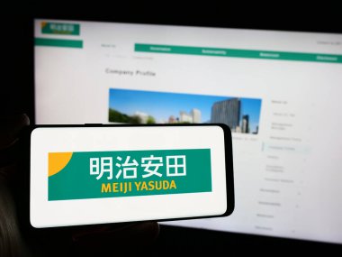 Stuttgart, Almanya - 04-12-2024: Japon iş adamı Meiji Yasuda Hayat Sigortası Şirketi 'nin logosunun bulunduğu cep telefonu web sitesinin önünde duruyor. Telefon ekranına odaklan.