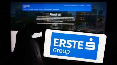 Stuttgart, Almanya - 04-13-2024: Avusturyalı finans hizmetleri şirketi Erste Group AG 'nin logosuna sahip akıllı telefon sahibi kişi web sitesi önünde. Telefon ekranına odaklan.