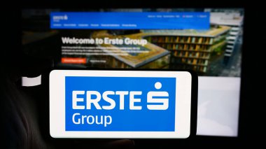 Stuttgart, Almanya - 04-13-2024: Avusturyalı finans hizmetleri şirketi Erste Group AG 'nin logosuyla cep telefonu tutan kişi web sayfası önünde. Telefon ekranına odaklan.