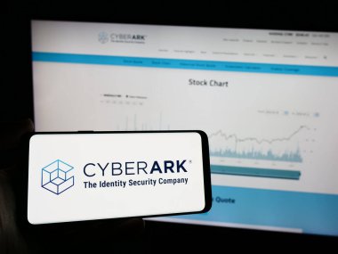 Stuttgart, Almanya - 04-13-2024: İnternet sayfasının önünde Amerikan kimlik güvenlik şirketi CyberArk Software Inc. 'in logosu olan cep telefonu sahibi kişi. Telefon ekranına odaklan.