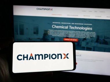 Stuttgart, Almanya - 04-17-2024: Web sitesi önünde ABD 'li petrol teknolojisi şirketi ChampionX Corporation' ın logosuna sahip kişi. Telefon ekranına odaklan.