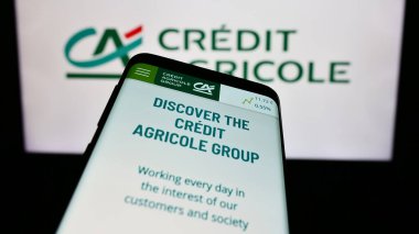Stuttgart, Almanya - 11-16-2023: Fransız finans hizmetleri şirketi Credit Agricole S.A. 'nın internet sitesiyle birlikte cep telefonu logosu önünde. Telefon ekranının sol üst kısmına odaklan.