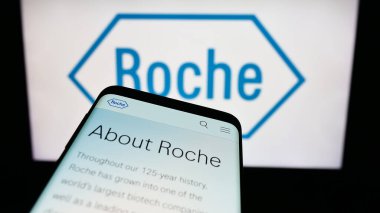 Stuttgart, Almanya - 11-16-2023: İsviçreli sağlık şirketi Roche Holding AG 'nin web sitesiyle birlikte iş logosu önünde cep telefonu. Telefon ekranının sol üst kısmına odaklan.