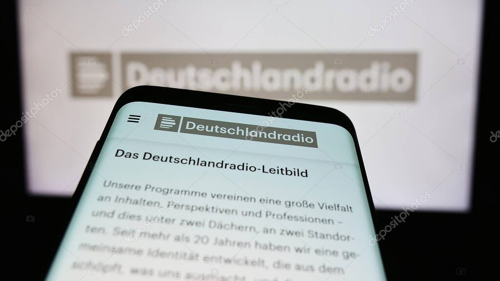 Stuttgart, Germany - 04-13-2024: Smartphone with website of German public radio broadcaster Deutschlandradio in front of logo. Focus on top-left of phone display.